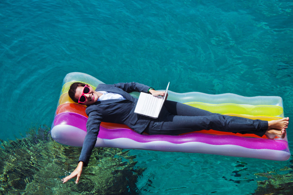 Happy businesswoman with laptop on floating mattress in red sea english for exams - kurs języka angielskiego - egzaminacyjny